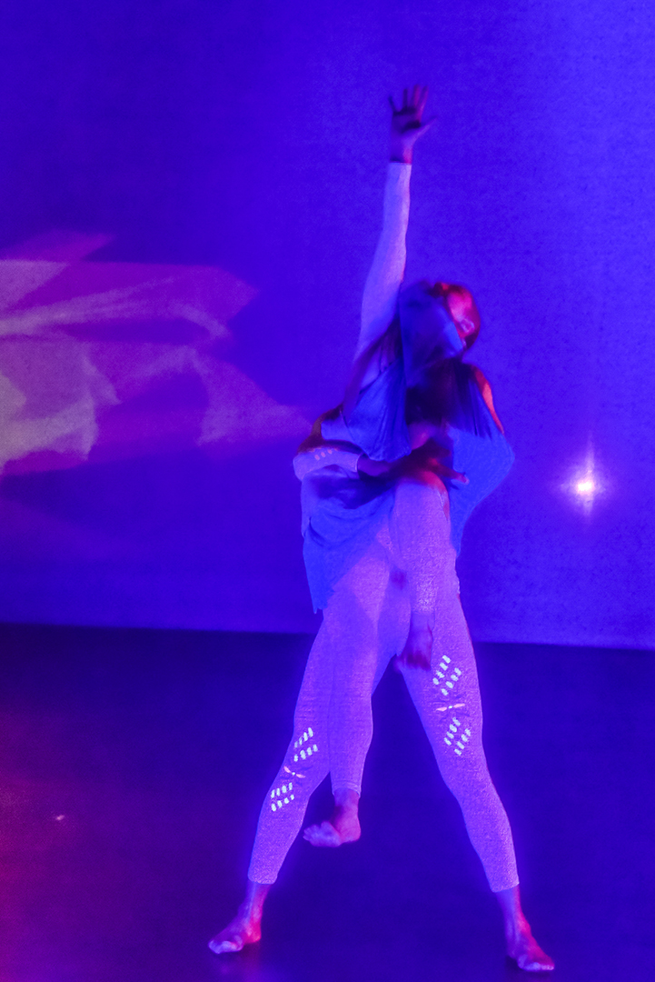 ESDC dancer lift in ultraviolet lights against purple polygonal trails during Kaatsbaan residency.